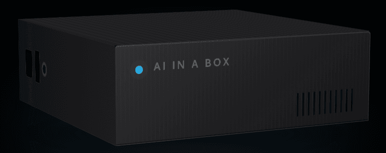 The AI in a Box appliance — a compact black on-site device with a lit cyan status indicator.